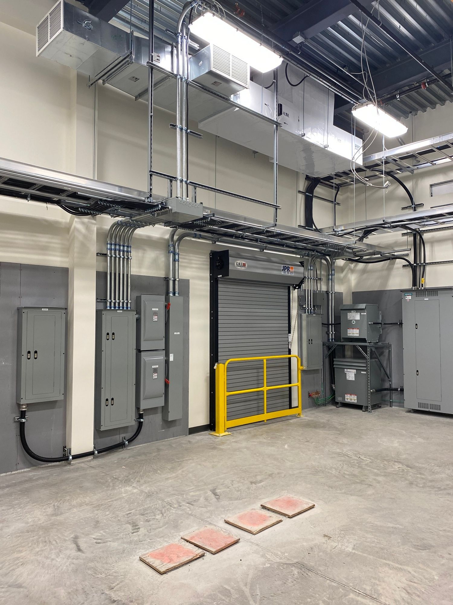 A large room with a lot of electrical equipment and a yellow barrier.