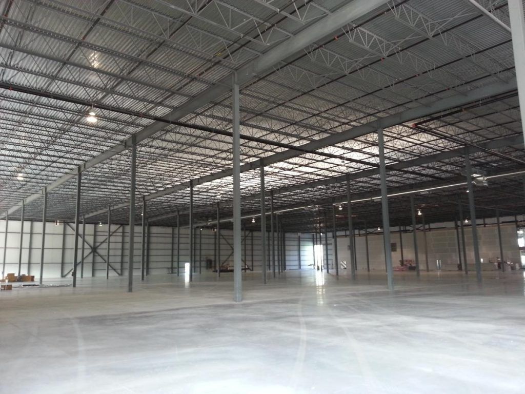 A large empty warehouse with a metal roof