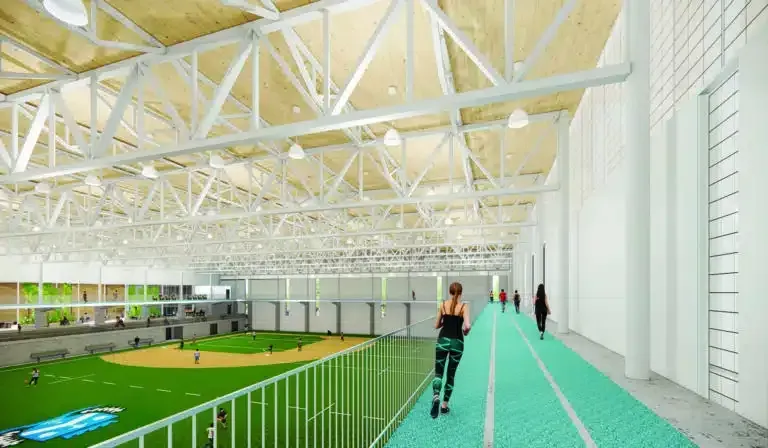 A woman is running on a track in a gym.