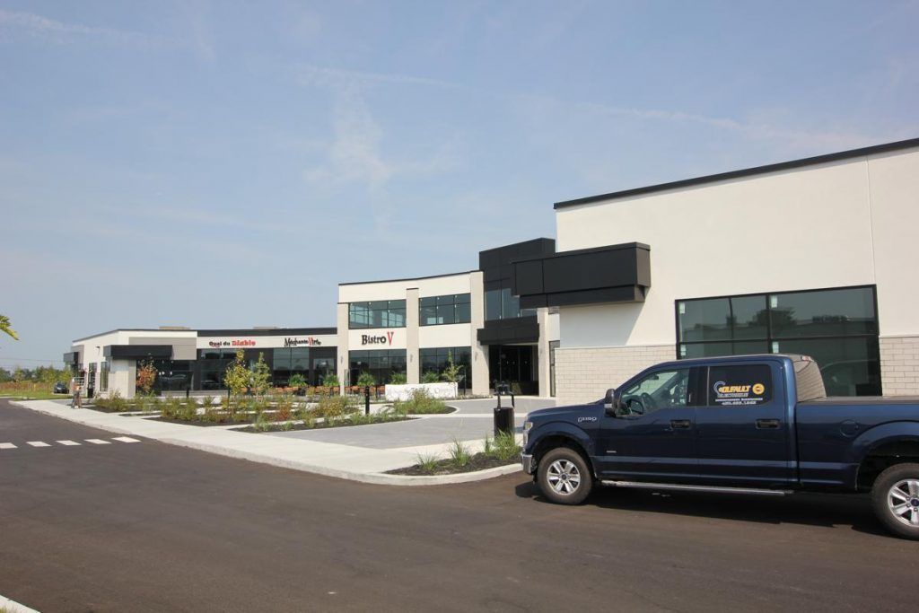 A blue truck is parked in front of a building.