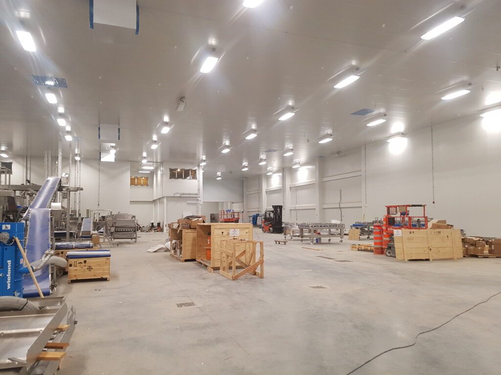 A large warehouse filled with lots of boxes and machinery.