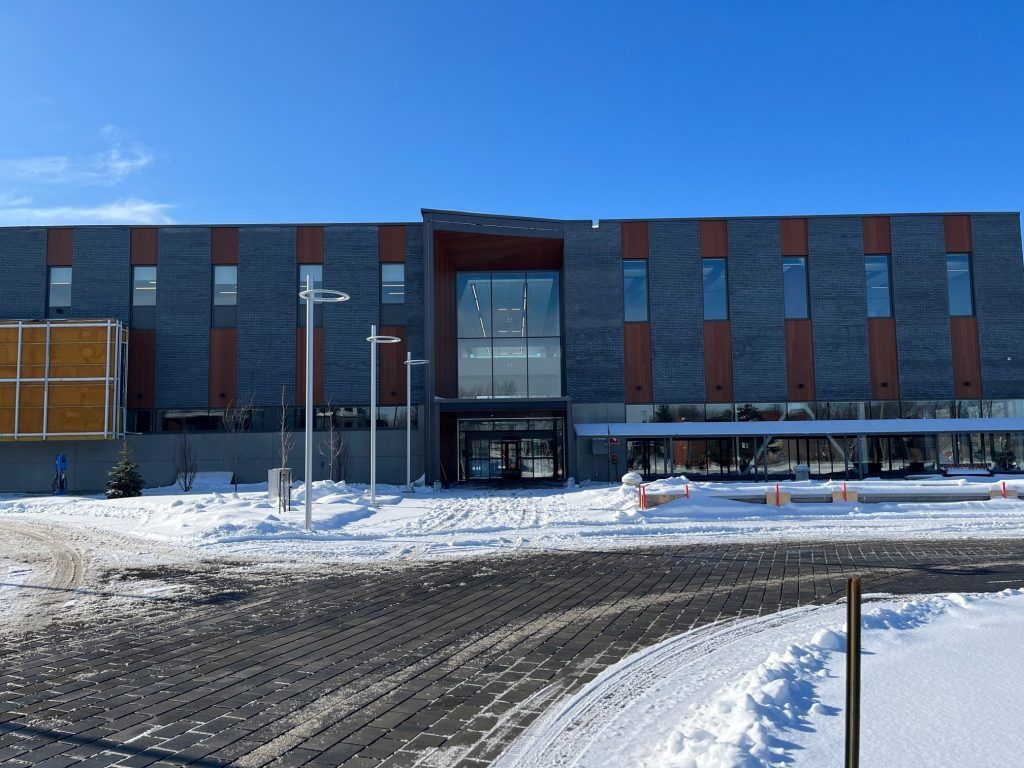 A large building with snow on the ground in front of it