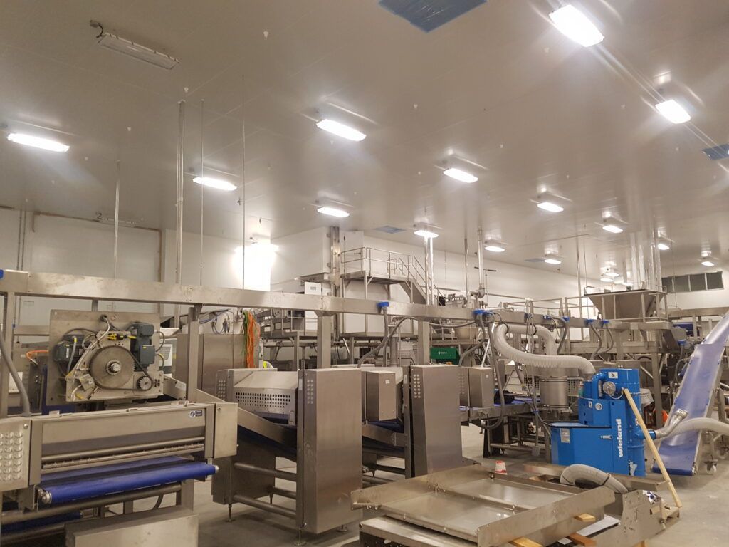 A large warehouse filled with lots of stainless steel machinery.
