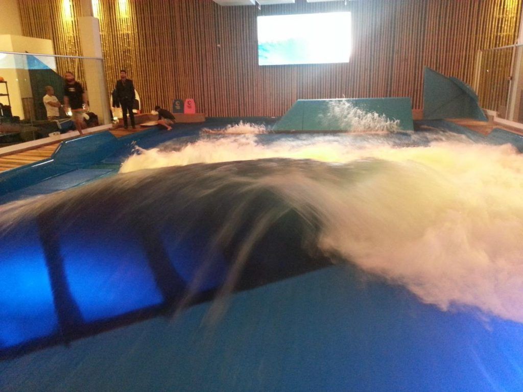 A person is riding a wave in a pool of water