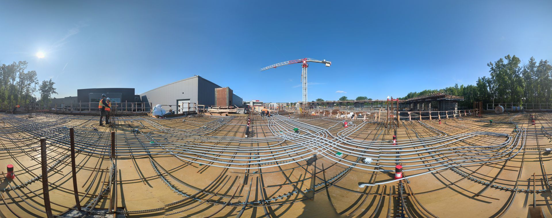 A panoramic view of a construction site with a crane in the background.