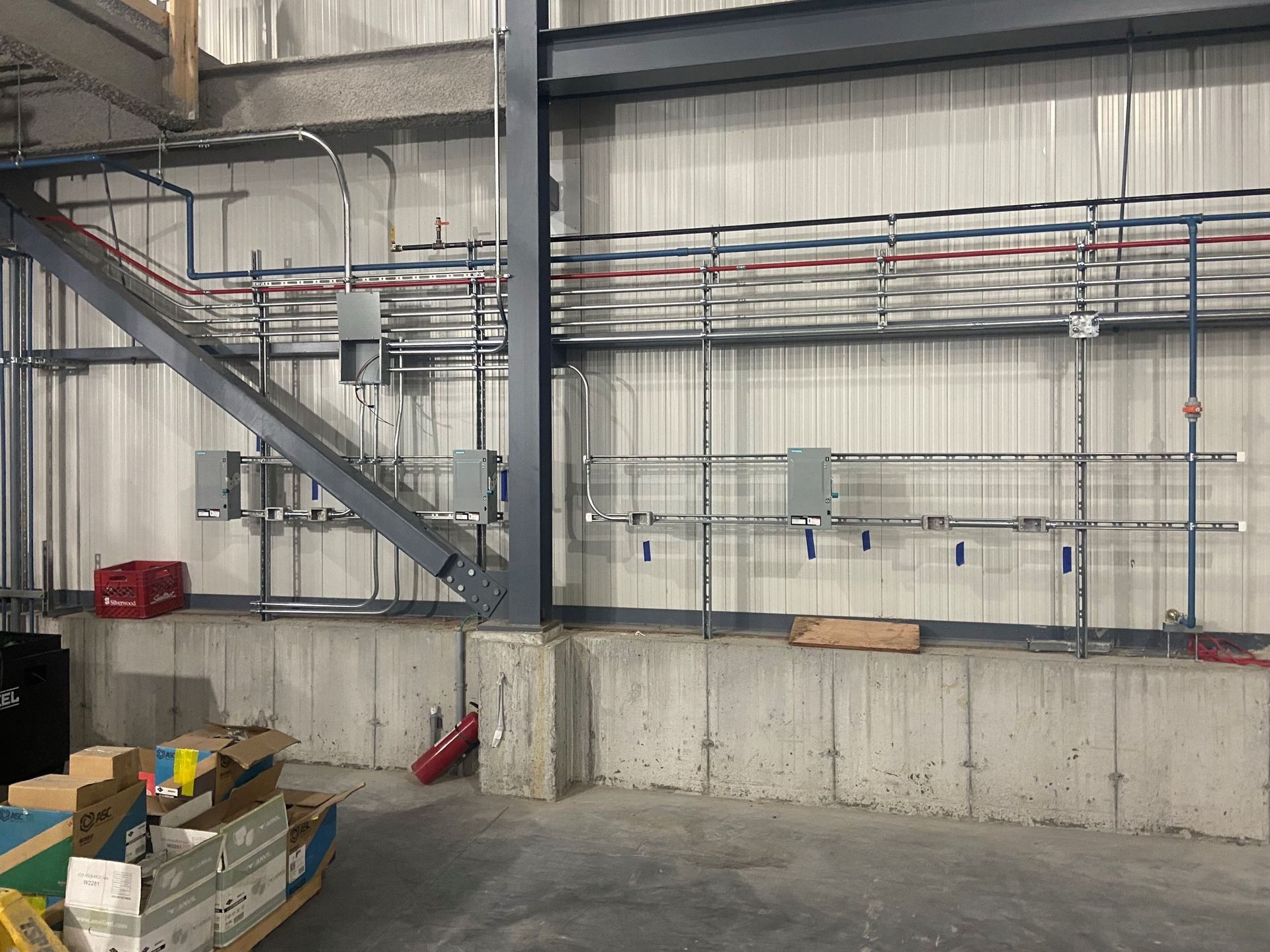 A warehouse with a lot of electrical wires hanging from the ceiling.