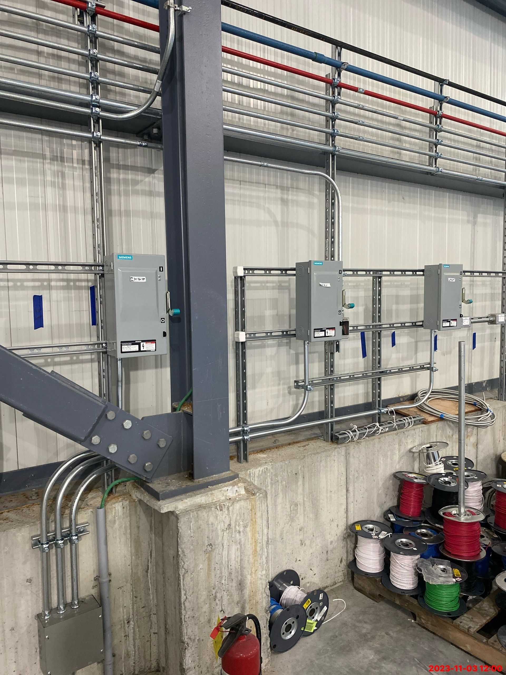 A warehouse with a lot of electrical wires hanging from the ceiling.