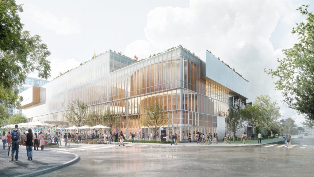 A large building with a lot of windows is surrounded by trees and people.