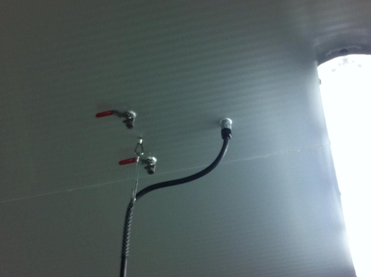 Three faucets are hanging from the ceiling of a room.
