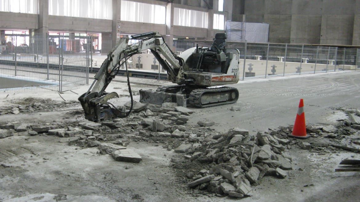 A small excavator is digging a hole in the ground.