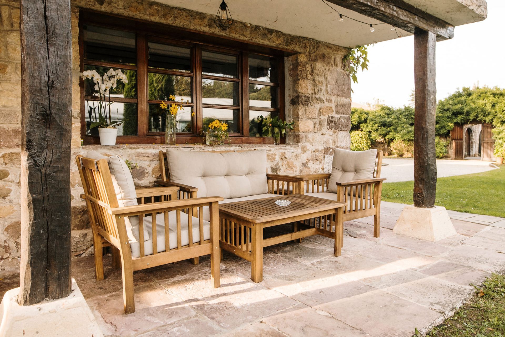 A porch with a couch , chairs , and a coffee table.