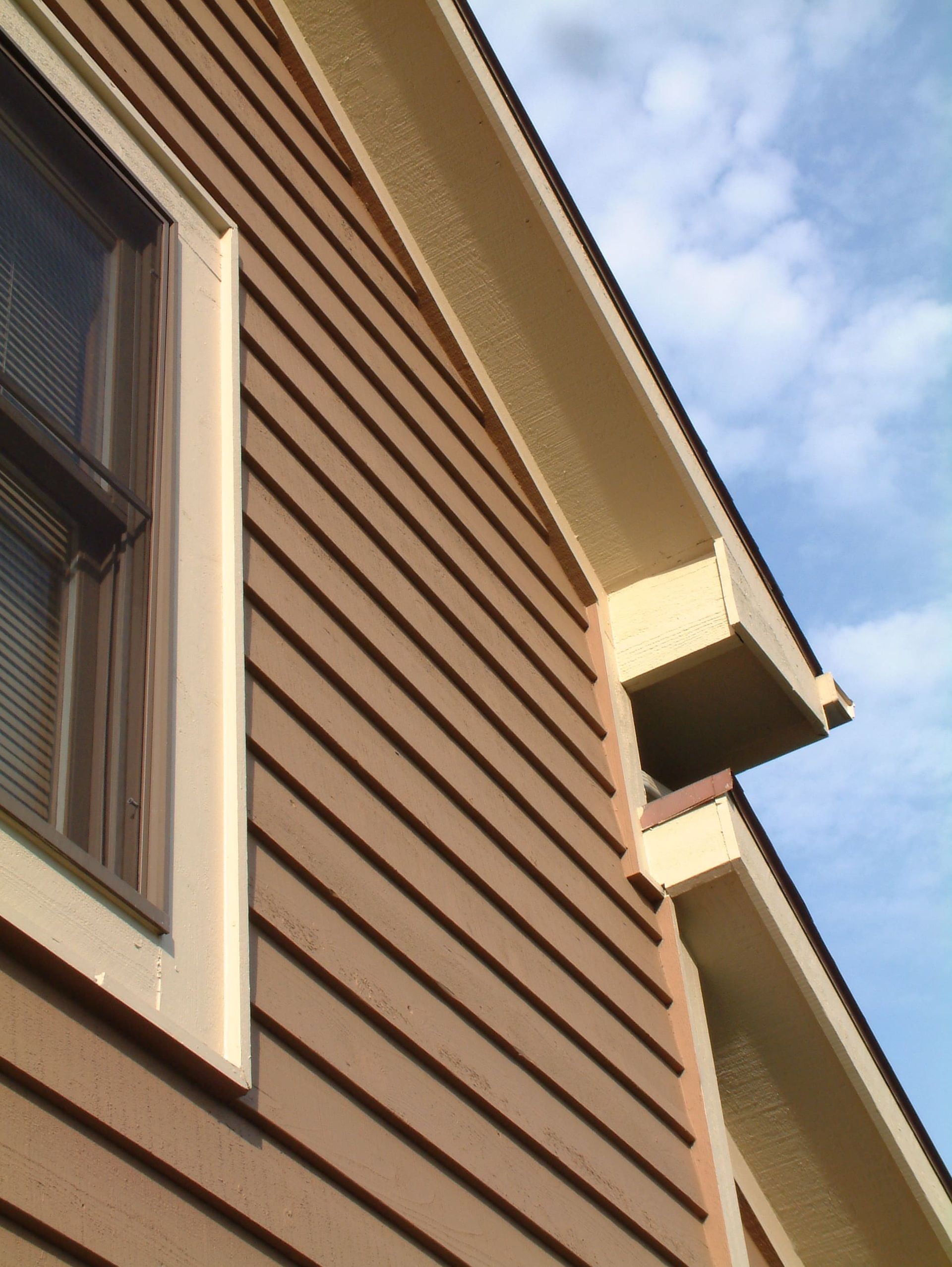 A brown house with a window on the side