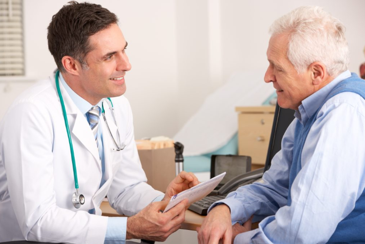 A doctor discusses paperwork with an elderly patient. 