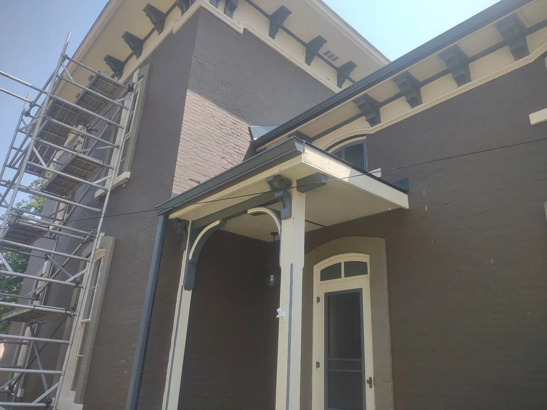 House exterior with scaffold on the left and a covered front porch under construction