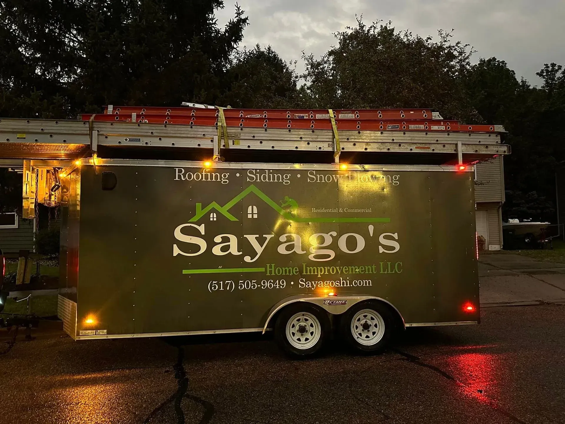 Sayago’s food trailer with string lights, parked outdoors at dusk under cloudy skies.