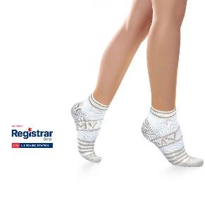 Piernas con calcetines blancos estampados hasta el tobillo sobre un fondo blanco, con un pequeño logotipo del Registrador a la izquierda.