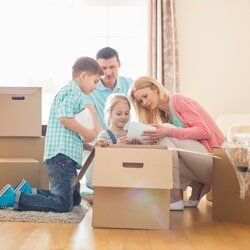 A family is moving into a new home and looking at a tablet.