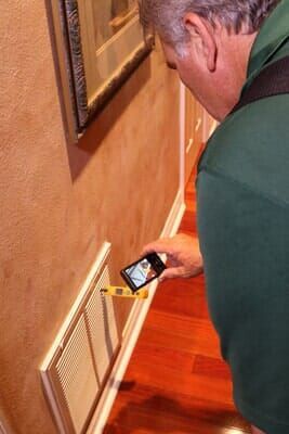 A man is measuring a wall with a tape measure.