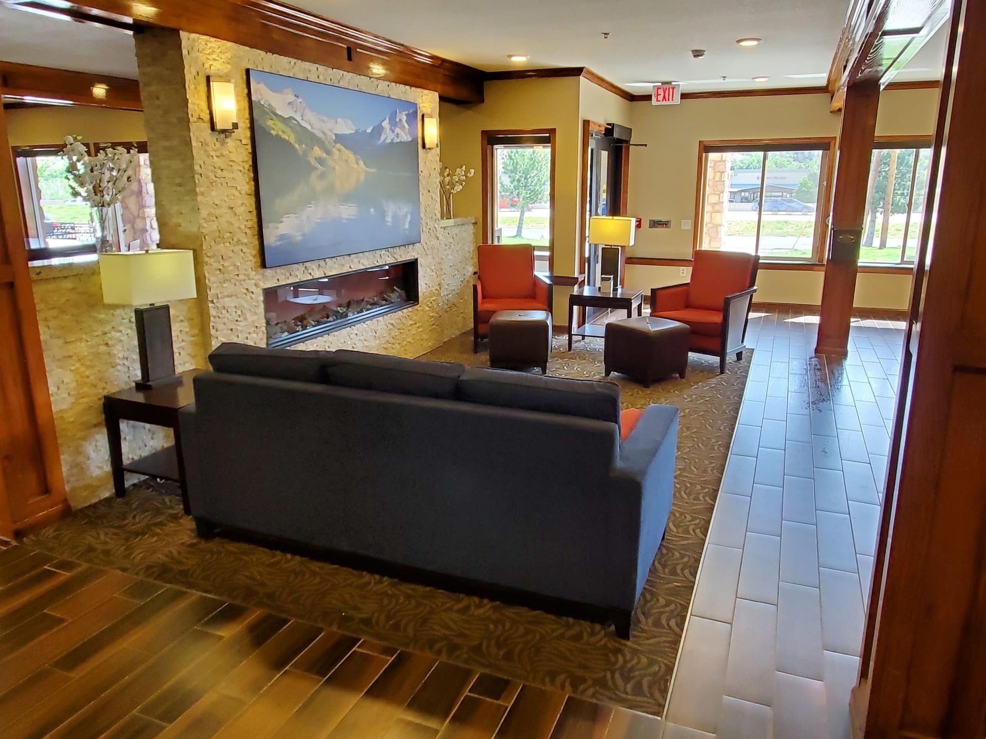 A living room with a couch , chairs , tables and a fireplace.