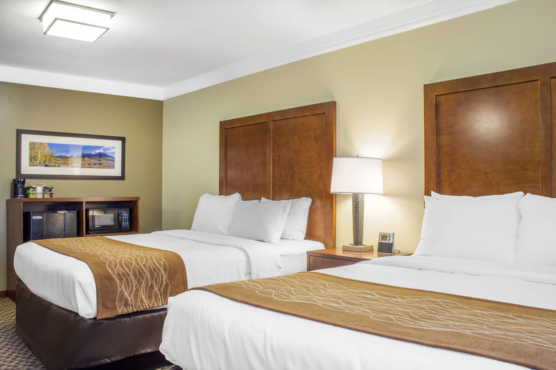 A hotel room with two beds and a lamp