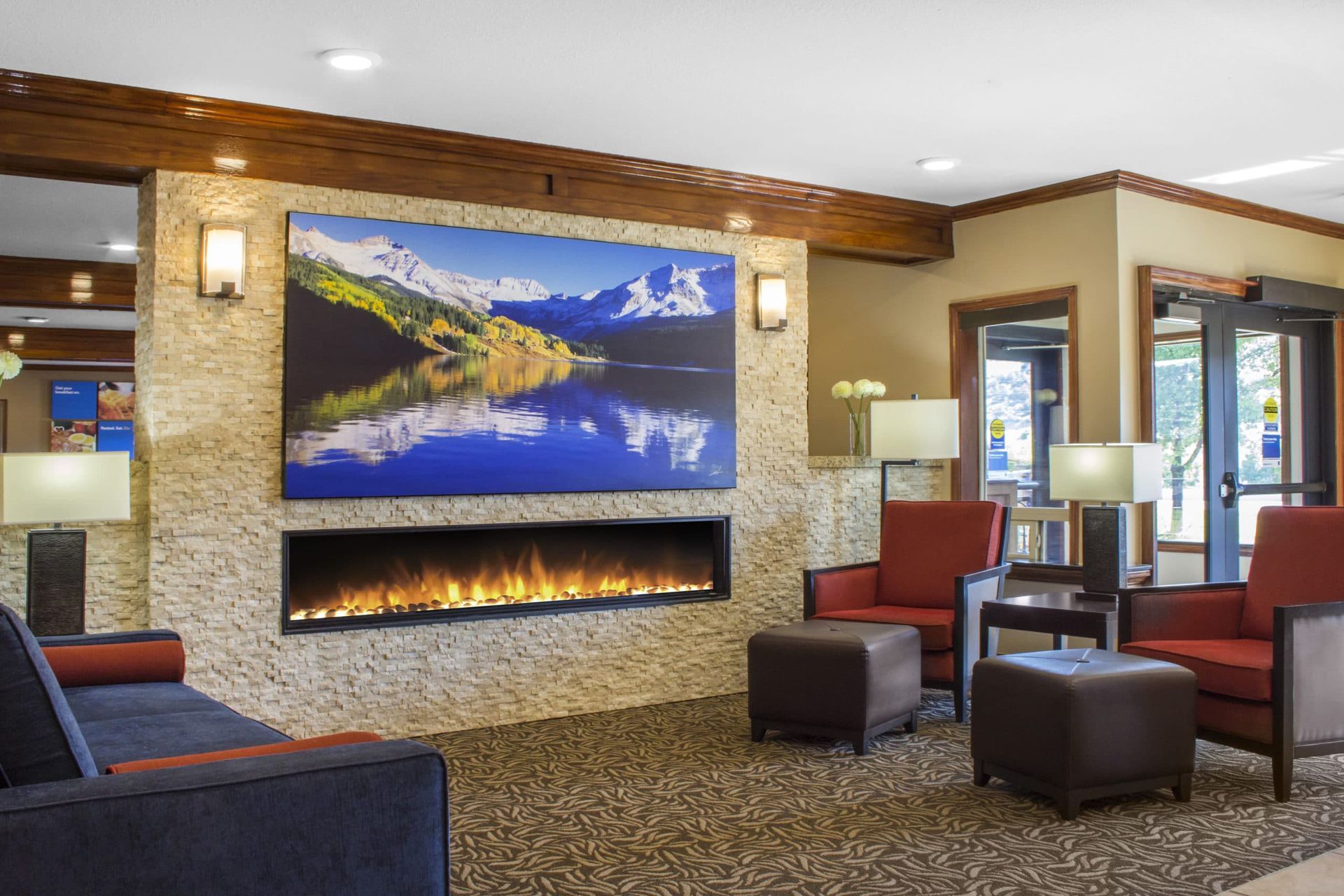 A hotel lobby with a fireplace and a painting on the wall