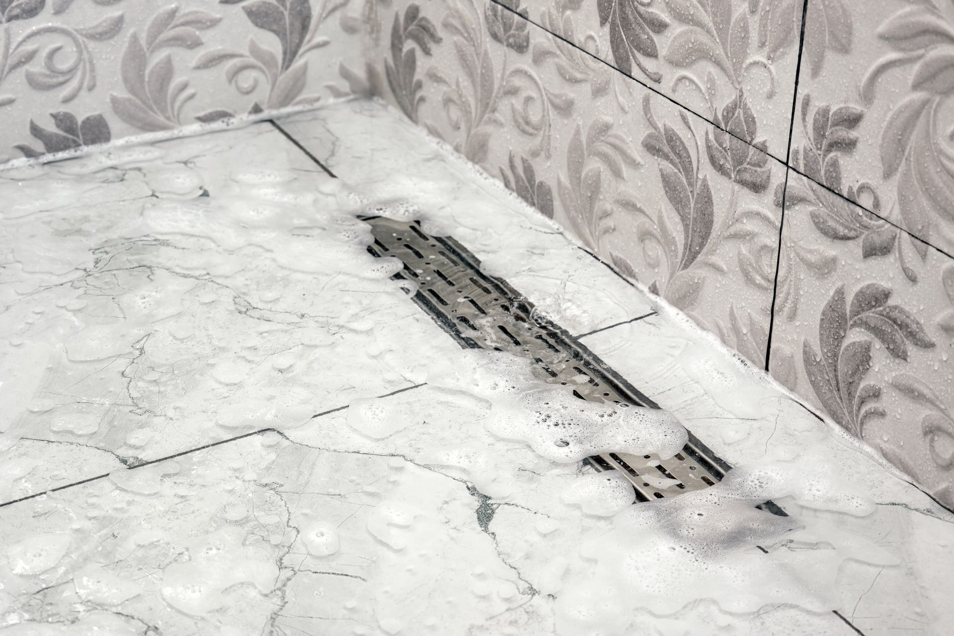 Broken floor drain surrounded by dust and debris in a tiled room corner Broken floor drain surrounded by dust and debris in a tiled room corner