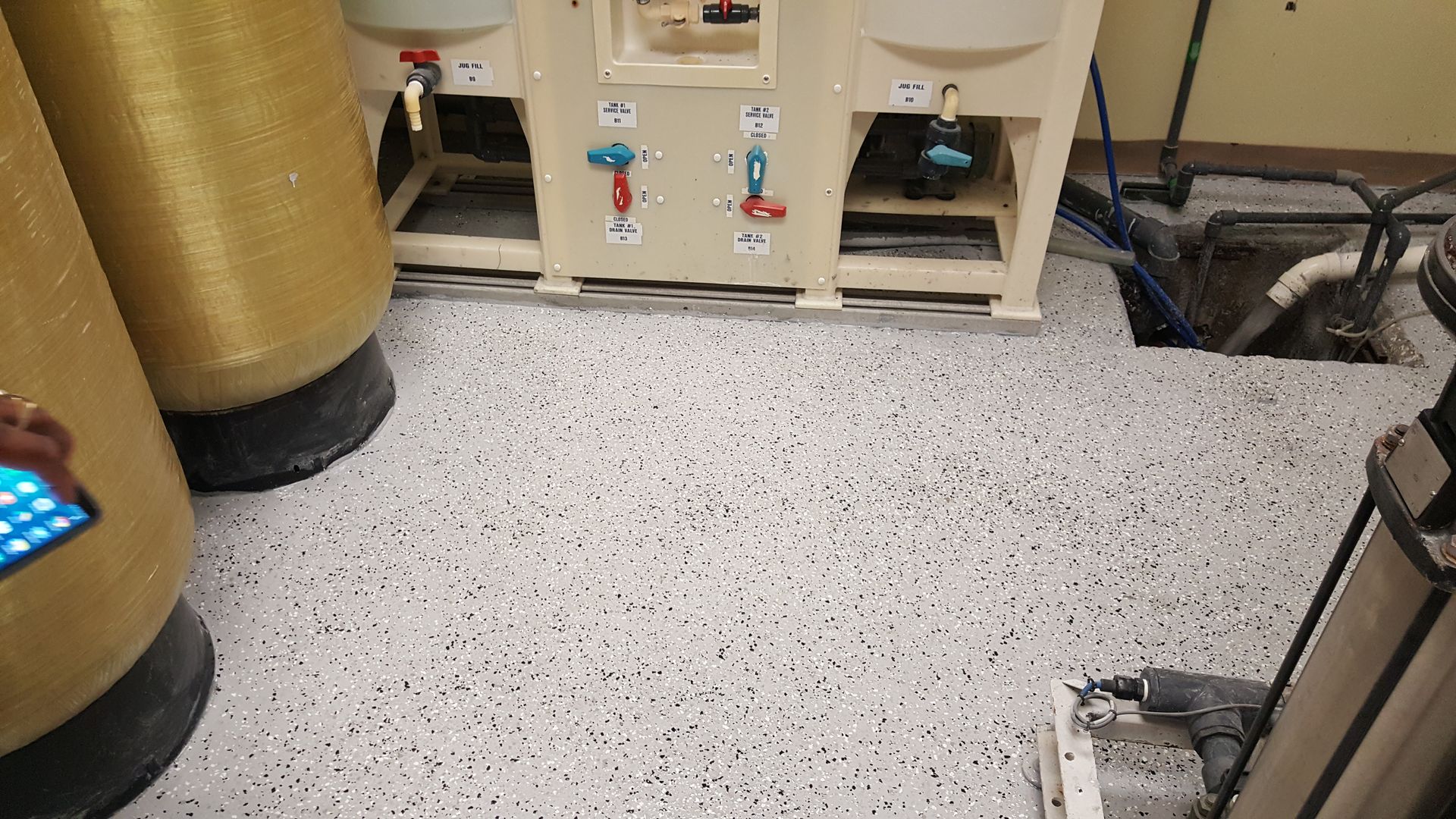 Industrial room with beige machines and a speckled gray floor.