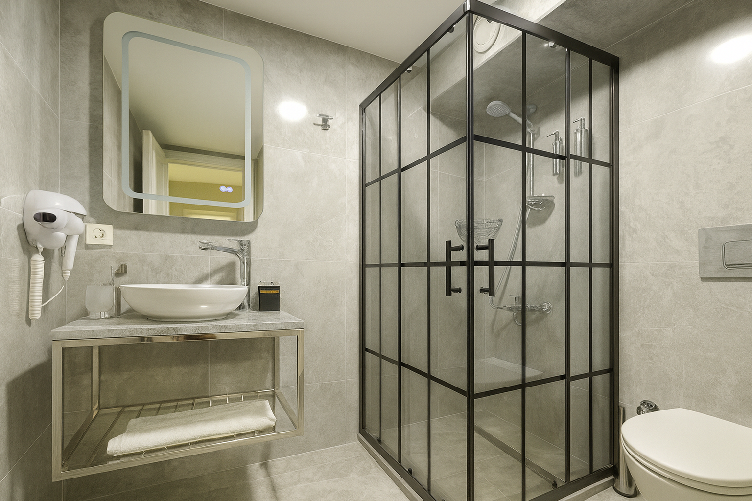 Compact modern bathroom with glass shower, sink vanity, mirror, and toilet in light gray tones