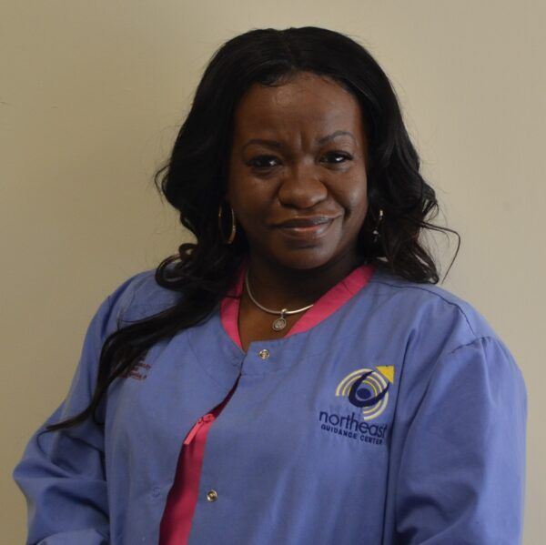 A woman wearing a blue northeast jacket smiles for the camera