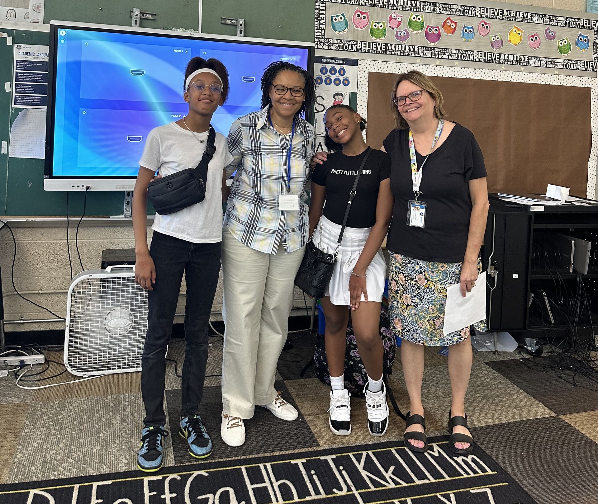A group of people posing for a picture in a classroom