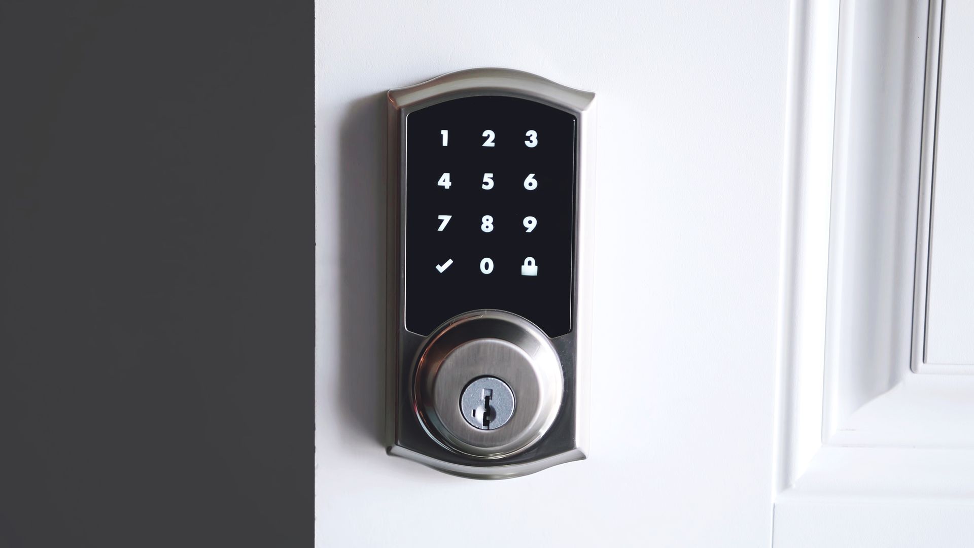 A close up of a digital door lock on a white door.