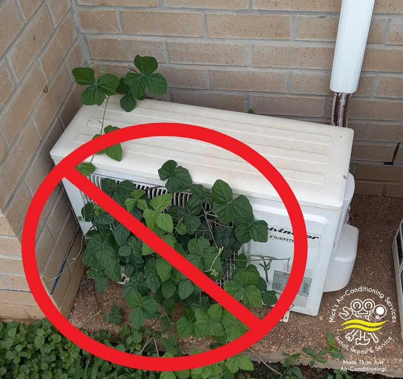Weeds Growing Around A Kelvinator Inverter — Mick’s Air-Conditioning Services in Gracemere, QLD Weeds Growing Around A Kelvinator Inverter — Mick’s Air-Conditioning Services in Gracemere, QLD