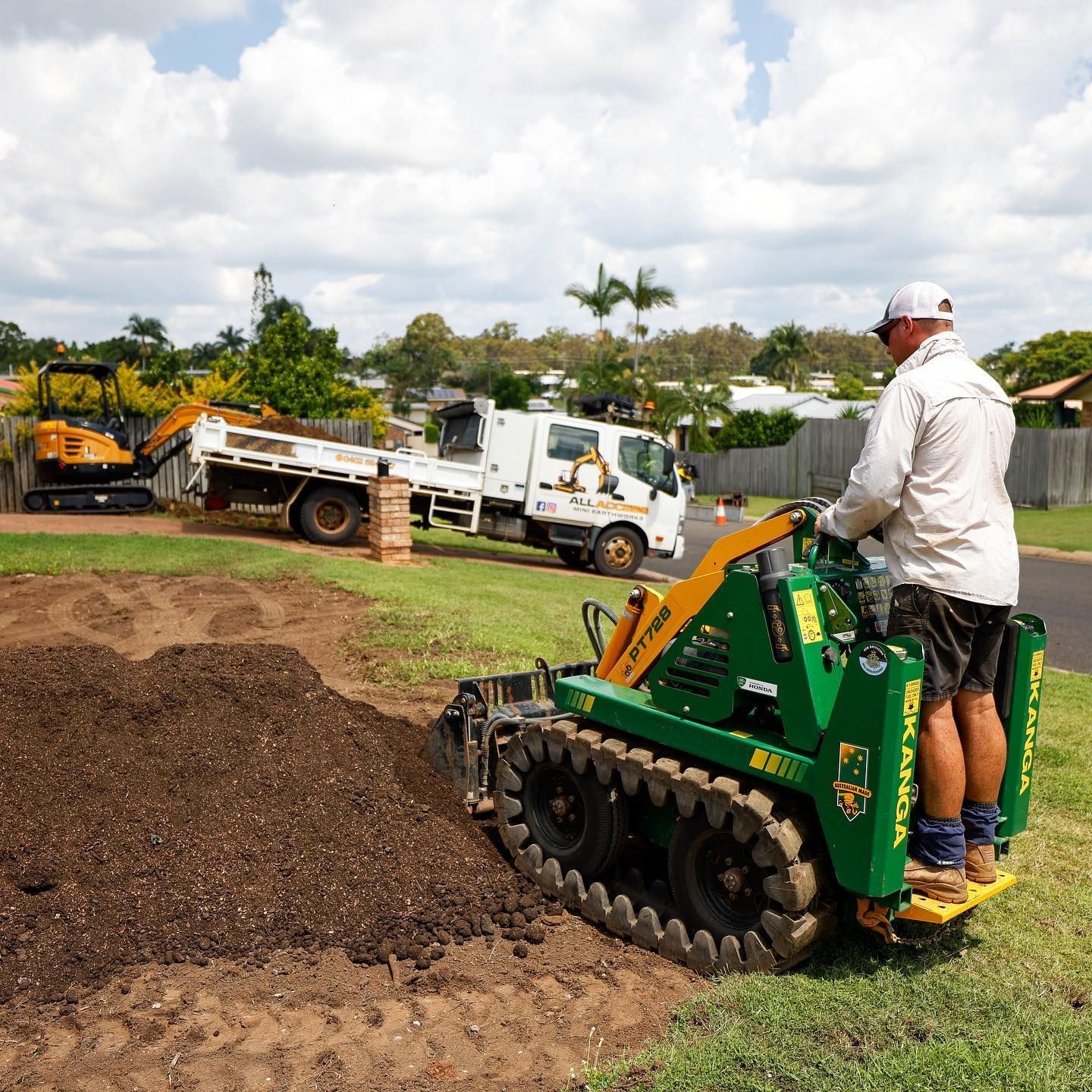 Man Operating a Green Mini-digger Moving Dirt — All Access Mini Earthworks in Innes Park, QLD