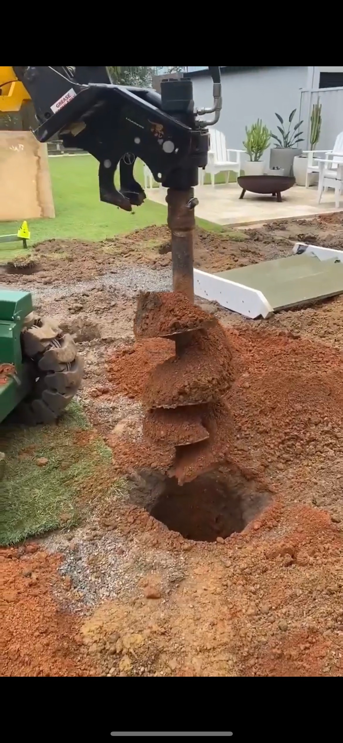 A Yellow Auger Drill Near a Fence and Grass. the Drill is Making a Hole — All Access Mini Earthworks in Innes Park, QLD