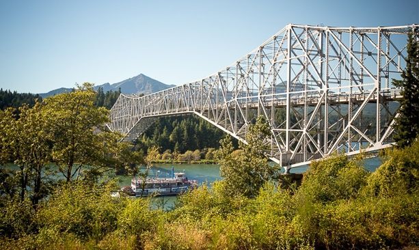 A bridge over a river with a boat in the water.