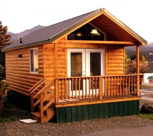 A small log cabin with a porch and stairs