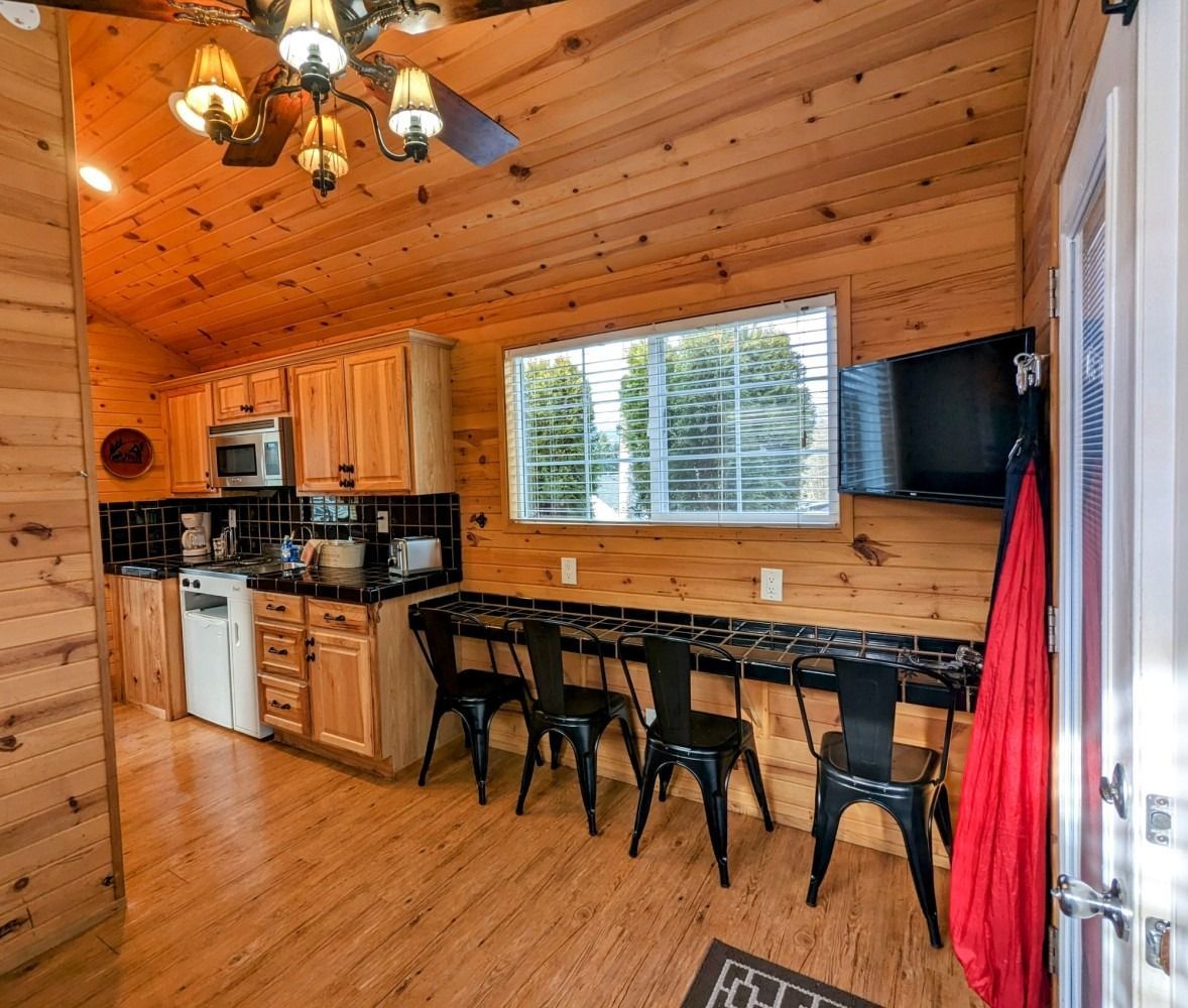 A kitchen with wooden cabinets and a ceiling fan