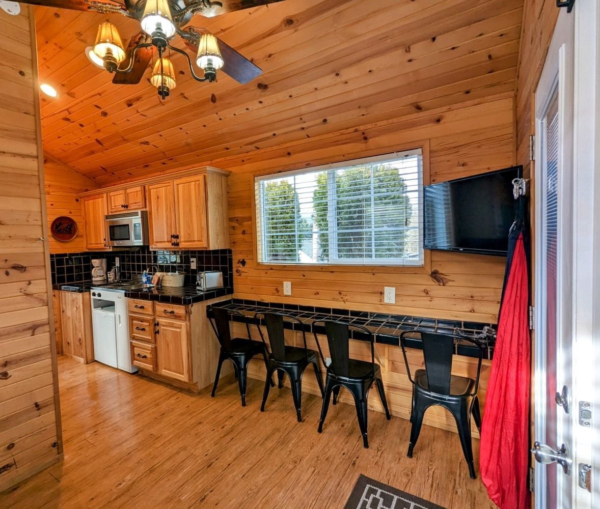 A kitchen with wooden cabinets and a ceiling fan