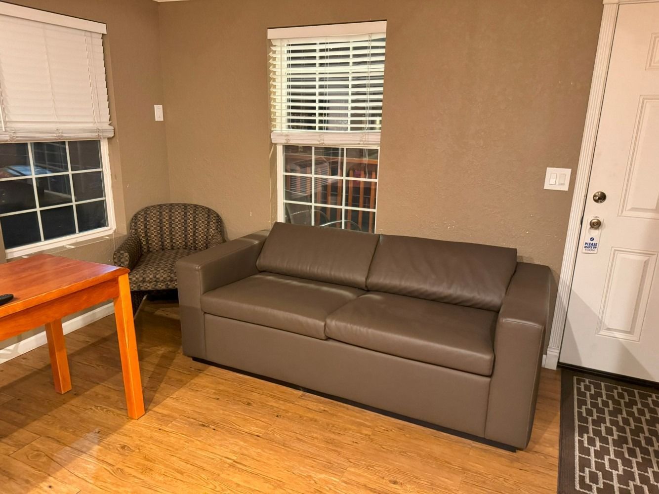 A living room with a couch , chair , table and window.