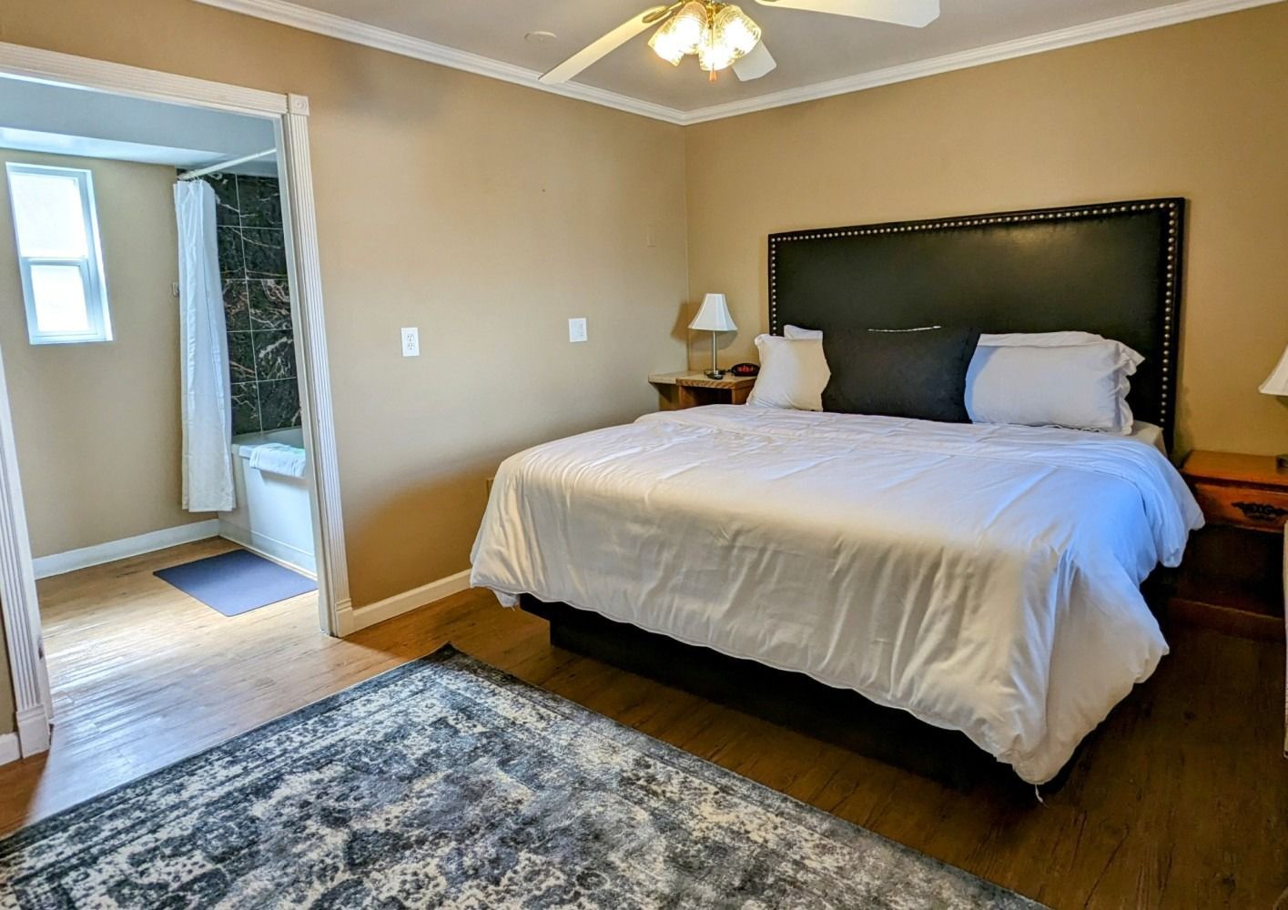 A bedroom with a king size bed and a rug.