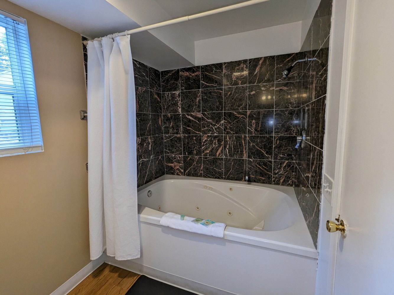 A bathroom with a jacuzzi tub and a shower curtain.