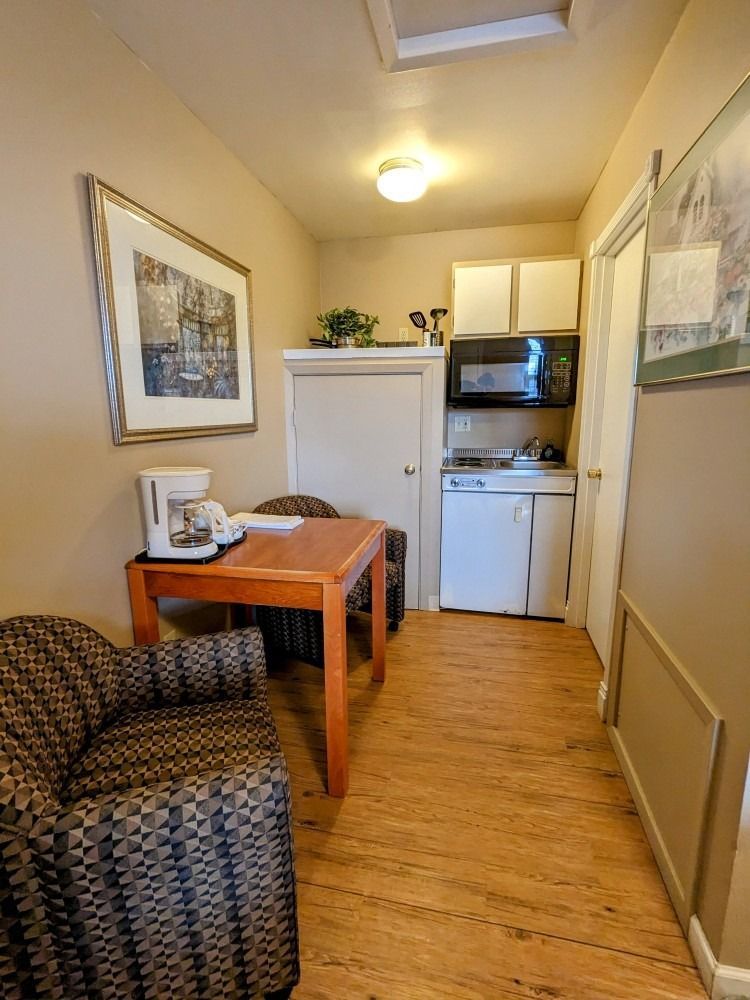 A small kitchen with a table and chairs in a hallway.