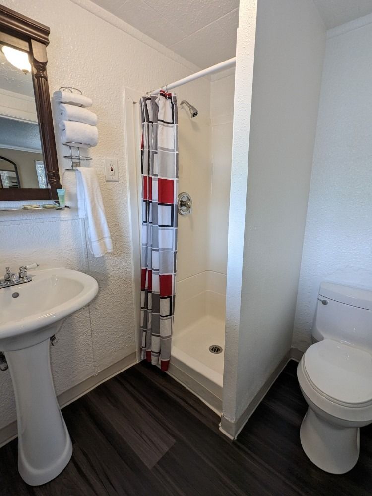 A bathroom with a sink , toilet and shower.