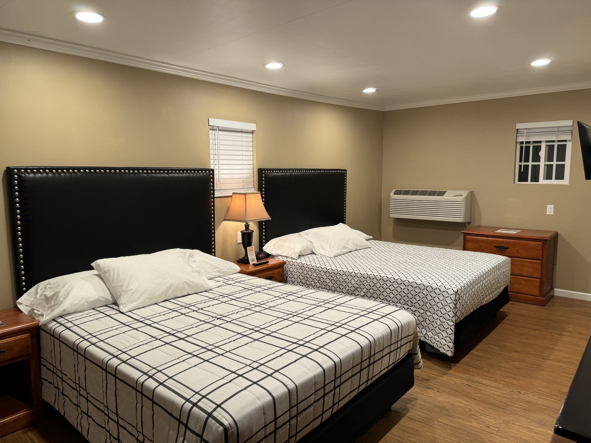A hotel room with two beds and a television
