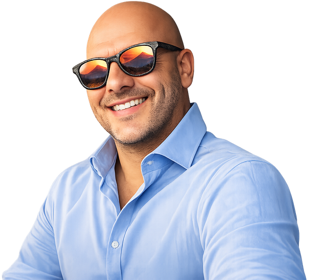 Uomo calvo con occhiali da sole, sorridente, camicia blu.