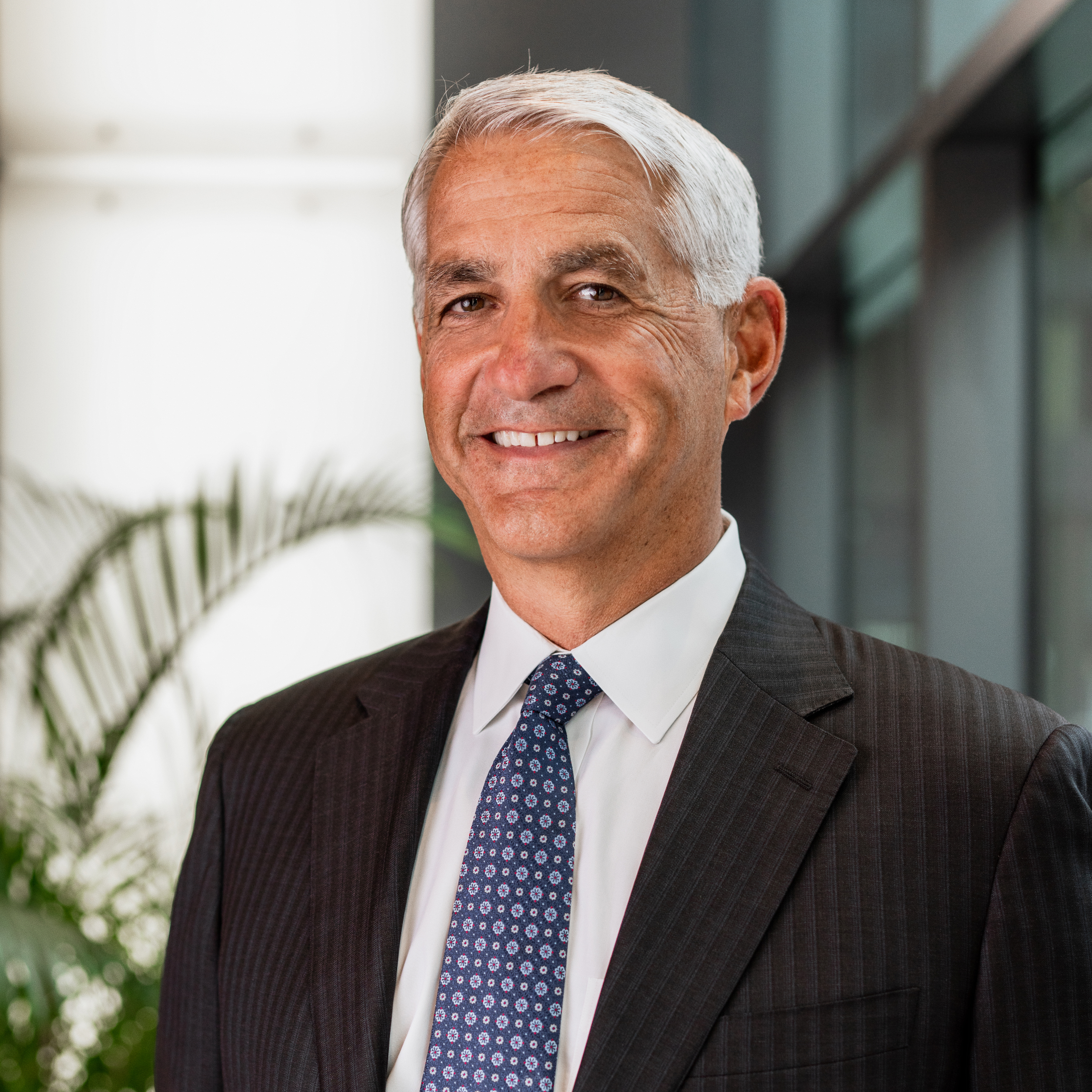 A man in a suit and tie is smiling for the camera