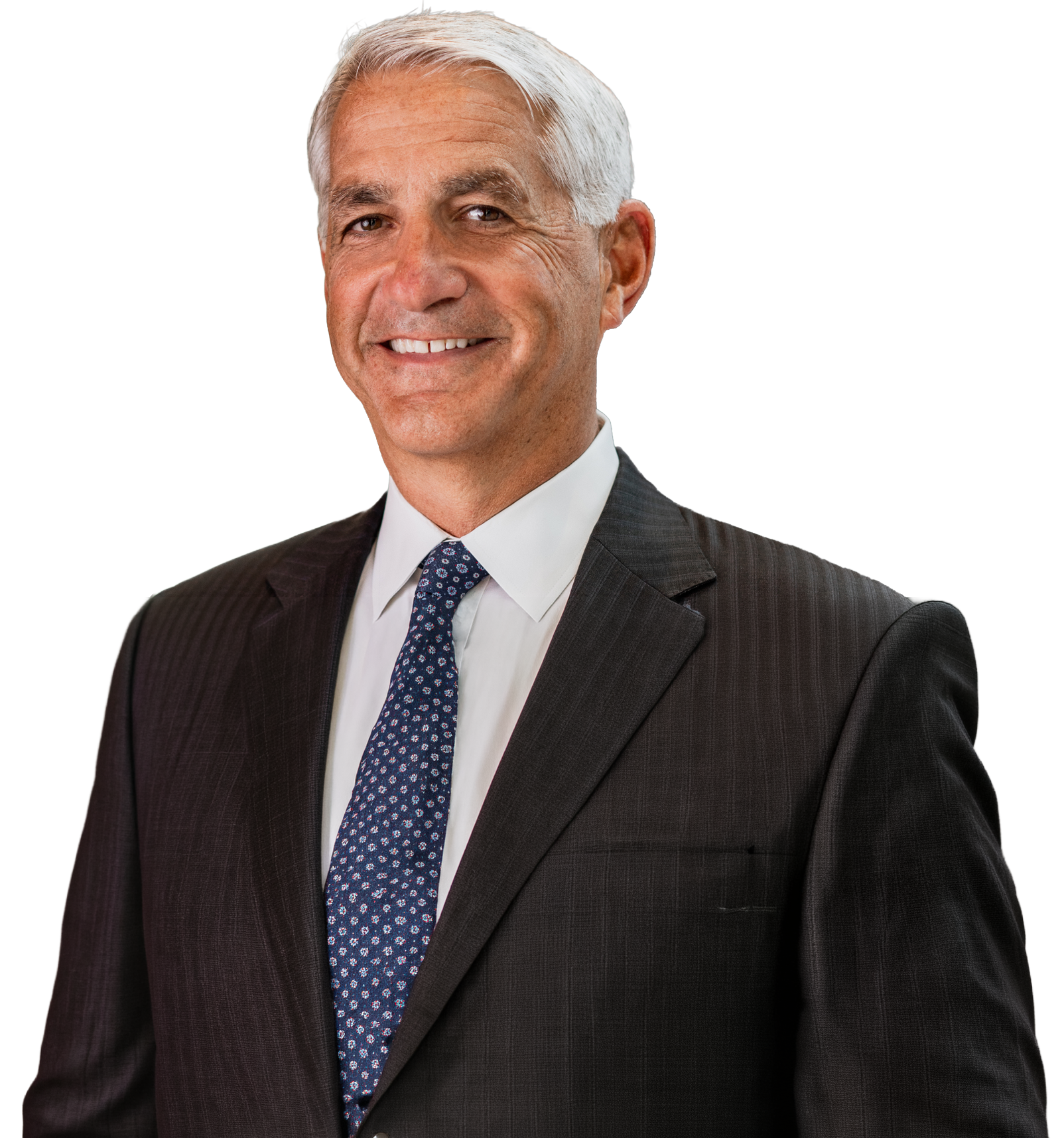 A man in a suit and tie is smiling for the camera