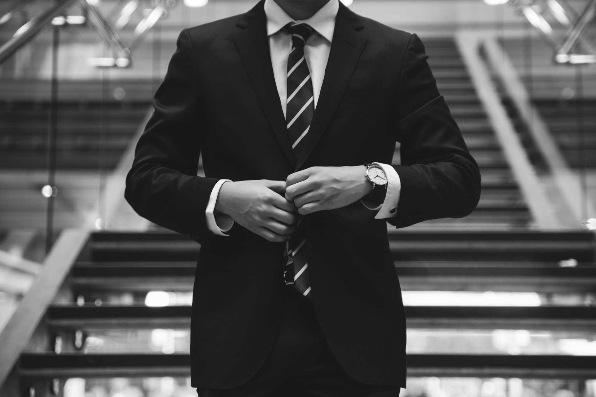 A man in a suit and tie is standing on a set of stairs.