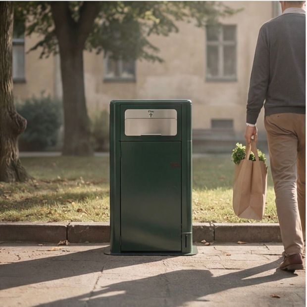 Green guardian Organic street trash bin on a sunny sidewalk, with a person carrying a paper bag nearby.