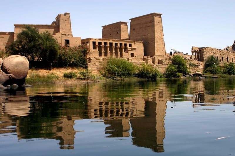 Ancient Egyptian temple complex reflected in calm water.